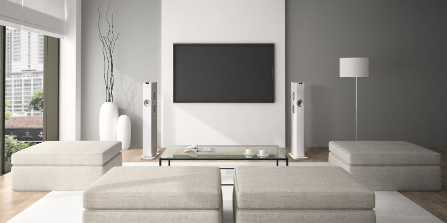 KEF LS60 Wireless speakers in Mineral White set-up either side of a large on-wall TV screen in a lounge.