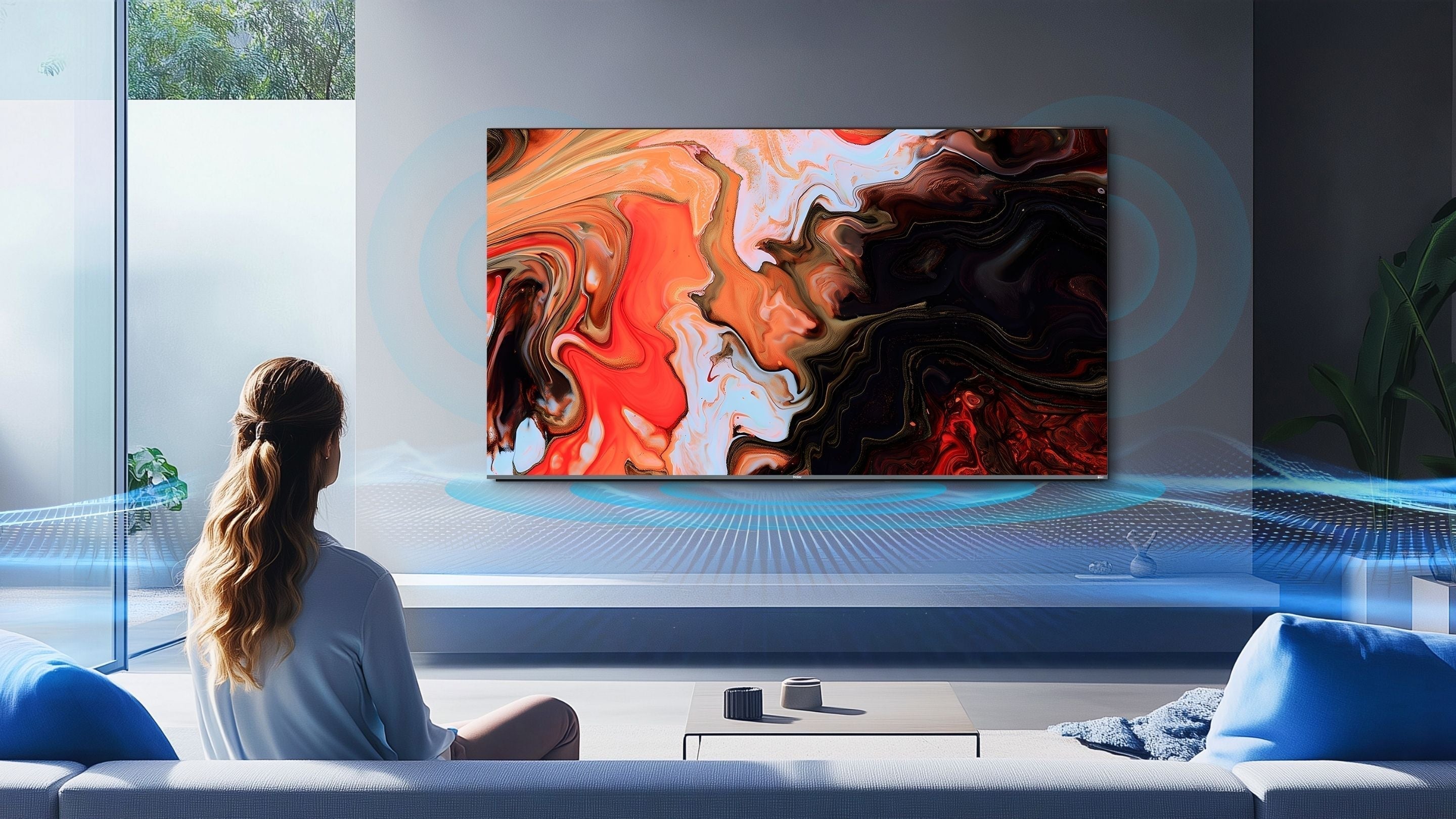 Person sitting on a couch in a modern living room, watching a colorful abstract painting on a large TV screen.