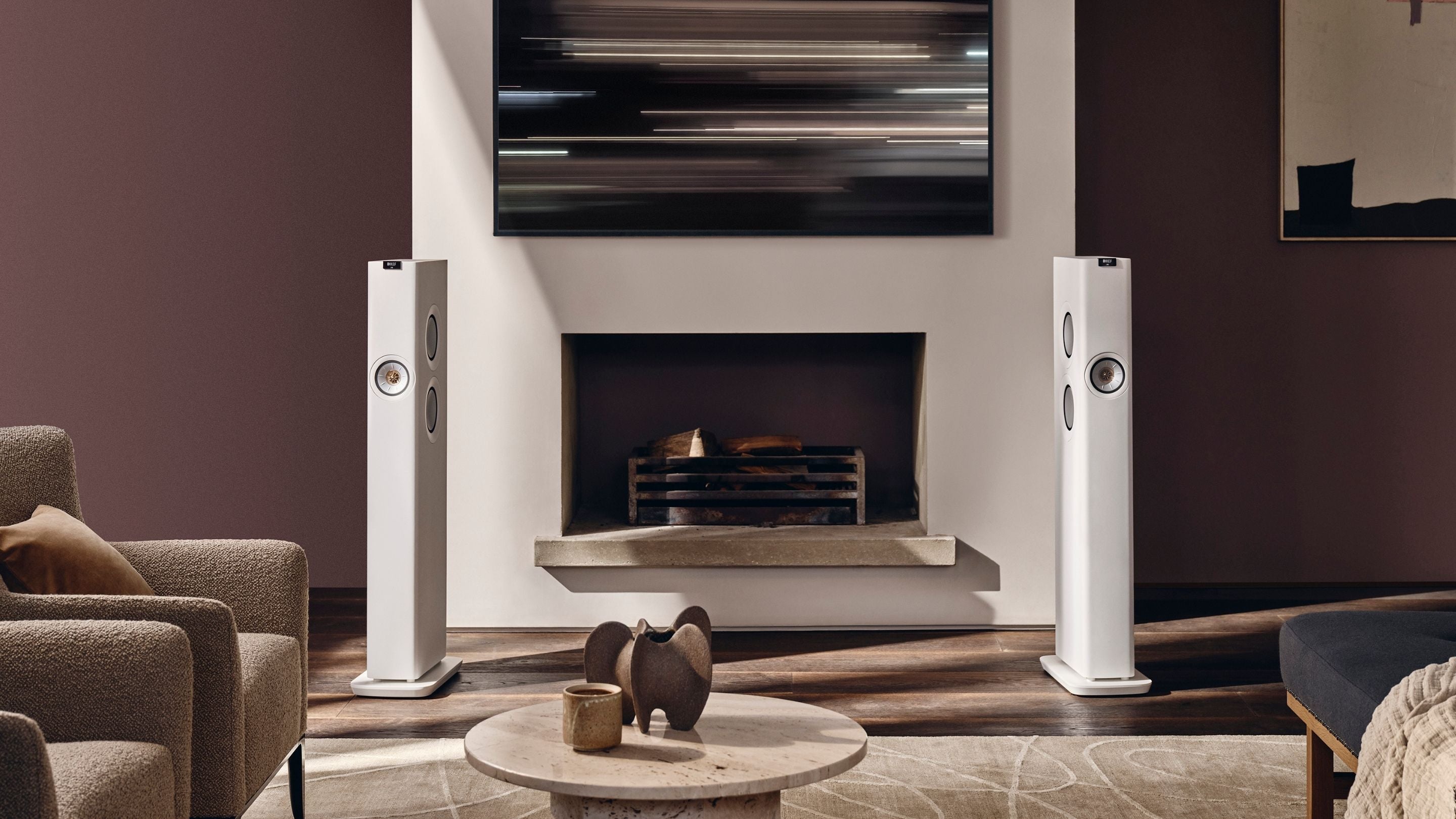 White KEF LS60 Wireless Speaker placed in modern living with a fireplace 